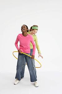 Two girls playing with hula hoop