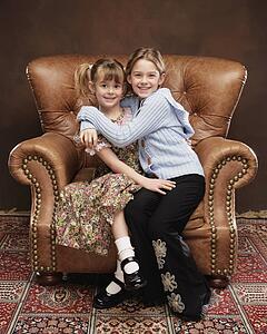 Two girls sitting in armchair