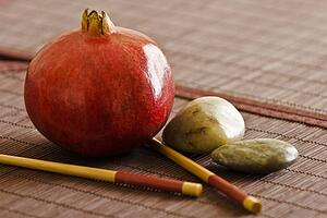 Pomegranate with chopsticks and pebbles