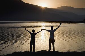 Children holding hands stretched up to the sky 