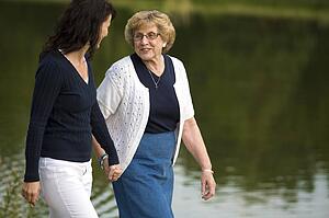 Two women walking beside a lake