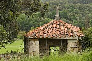 Pantiled roof shrine with stone cross in Rioseco, Northern Spain