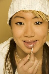 Woman applying lip gloss