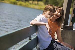 Teenagers sitting on a bench by water