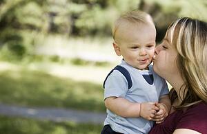 A mother kissing a boy