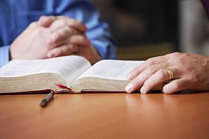 Bible and praying hands