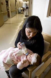 Woman bottle feeding baby girl