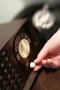 Woman changing dial on old radio
