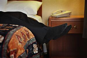 Male feet hanging off of bed