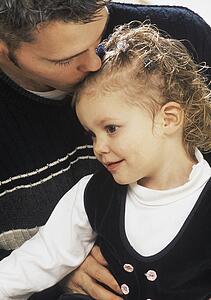 Father kissing daughter on the head