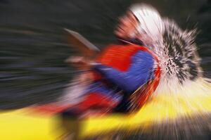 Blurred image of man in yellow kayak