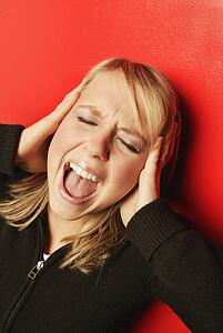 Woman with hands over ears