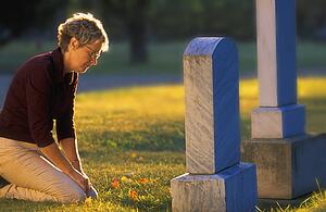Woman kneeling at grave