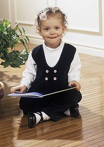 Girl reading book on floor