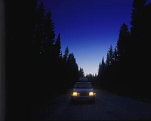 Cars on remote forest road at twilight
