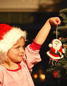 Girl Hanging Ornament on Christmas Tree