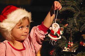 Girl Hanging Ornament on Christmas Tree