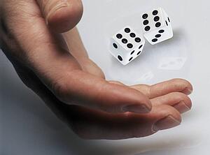 Hand rolling dice on white surface