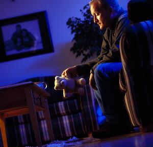 Man looking at teddy bear
