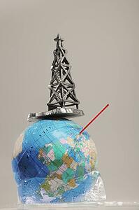 Globe in ice with straw and oil drilling rig