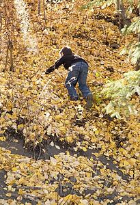 Boy climbing a steep hill in fall