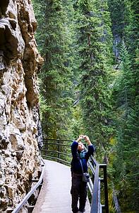 A boy using a camera in Johnson Canyon, Banff, Alberta, Canada