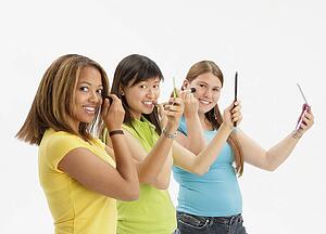 Three teens applying make up