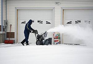 Man operating a snow blower