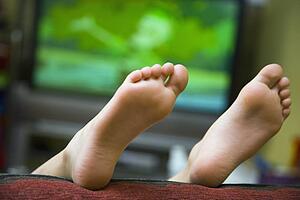 Child lying on sofa with feet in air 
