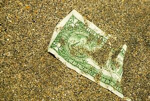 American dollar buried in the sand