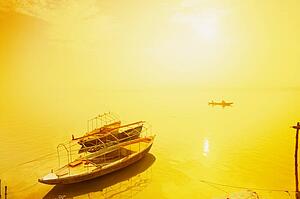 Sun shining on a boat on the Ganges river, India