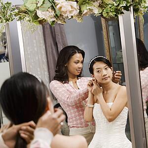 Woman helping bride with hair
