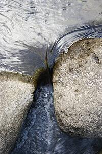 Close up shot of water flowing between two rocks in Iao Valley State Park in Maui Hawaii