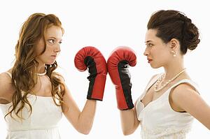 Brides holding boxing gloves up to each other