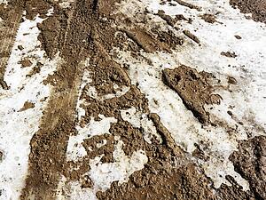 Close up shot of muddy and snowy dirty road.