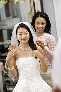 Friend holding bride's veil