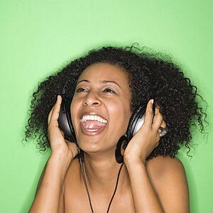 African-American woman listening to music through headphones.