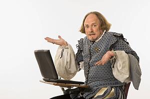 William Shakespeare sitting desk with laptop 