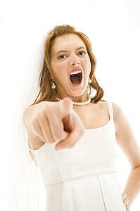 Caucasian bride screaming and pointing finger at viewer.