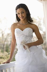 Portrait of bride leaning against railing