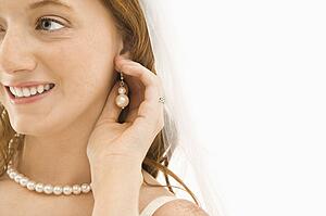 Bride adjusting her earring
