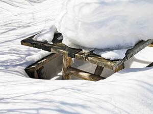 Picnic table covered in snow.