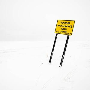 Minimum maintence road sign in deserted winter blizzard.