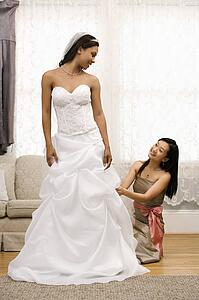 Bridesmaid fixing bride's dress