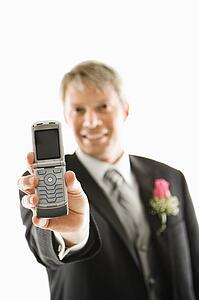 Groom holding out his cellphone 