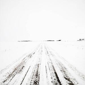 Deserted dirt road in blizzard.