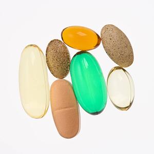 Close up of supplement vitamin pills against white background.