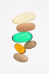 Close up of supplement vitamin pills against white background.