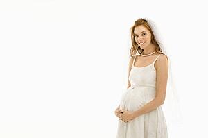 Pregnant bride with hands on her belly