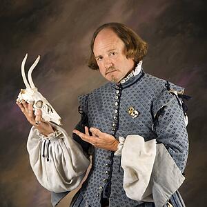 William Shakespeare in period clothing holding deer skull and looking at viewer